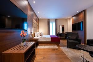 a hotel room with a bed and a couch and a table at Hotel De‘Andros Virpazar in Virpazar