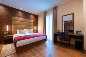 a bedroom with a bed and a desk and a computer at Hotel De‘Andros Virpazar in Virpazar