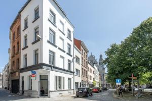 ein weißes Gebäude am Straßenrand in der Unterkunft Light Modern Apartment in the Heart of Antwerp in Antwerpen
