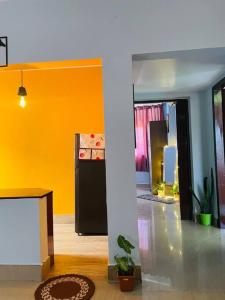 a living room with a yellow wall and a table at Urban loft cozy 1bhk Homestay in Guwahati
