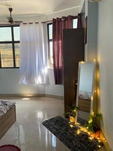 a bedroom with a mirror and a bed and window at Urban loft cozy 1bhk Homestay in Guwahati +3 photos