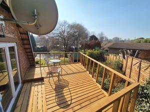 a wooden deck with a table and chair on it at Air Lakehouse in Hilton