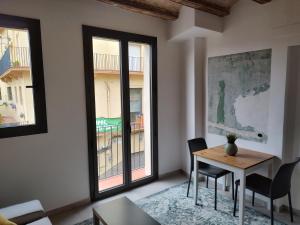 a living room with a table and chairs and windows at ANTIC Manresa 1 in Manresa