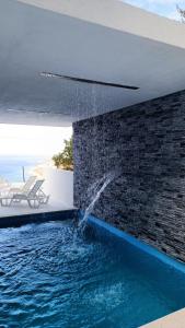 a pool with a water fountain in a house at Holiday House "M" Omiš - Newly renovated house with swimming pool, 3 rooms, gym, large terrace with amazing view on town and 6 parkplaces in Omiš