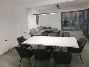 a dining room with a white table and chairs at Holiday House "M" Omiš - Newly renovated house with swimming pool, 3 rooms, gym, large terrace with amazing view on town and 6 parkplaces in Omiš +82 photos