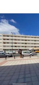ein Parkplatz mit Autos vor einem großen Gebäude in der Unterkunft Cozy-Apartment in San Bartolomé de Tirajana + 10 Fotos