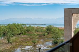 a view of a field with trees and water at Hotel De‘Andros Virpazar in Virpazar