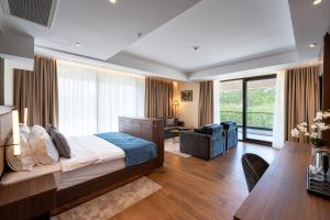 a bedroom with a bed and a desk and a couch at Hotel De‘Andros Virpazar in Virpazar