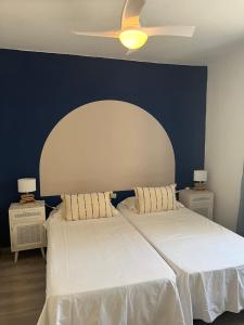 sypialnia z dwoma łóżkami i wentylatorem sufitowym w obiekcie CORNELIA`S HOME TC2 playa w mieście Los Cristianos