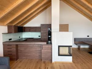 a kitchen with wooden cabinets and a fireplace at Bergchalet mit Panoramablick Diex in Diex