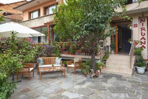 a patio with chairs and a table and an umbrella at Nirvana Guest House in Nesebar