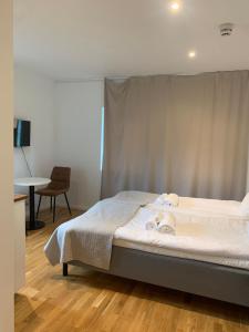 a bedroom with a bed and a table and a chair at Edsviken Hotell in Stockholm