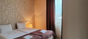 a hotel room with two beds and a window at Hotel Svanseti in Mestia