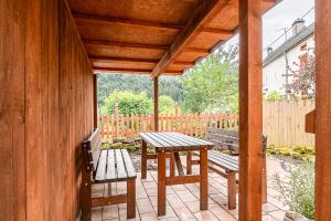 a porch with two benches and a table and a fence at Die Alte Metzgerei in Malberg +11 photos