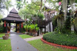 清迈Vimarn Kaew Village and Resort的一座带凉亭的建筑和一座植物建筑