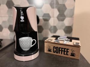a coffee maker with a cup next to a box at Casa Del Corso in Maletto