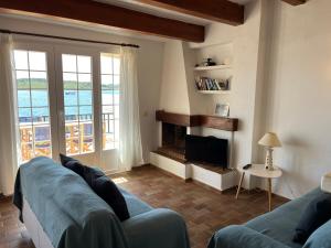 salon z kanapą i kominkiem w obiekcie Es CASTELL 2 7 by SOM Menorca w mieście Fornells