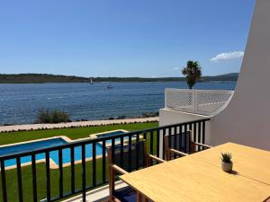 balkon ze stołem i widokiem na wodę w obiekcie Es CASTELL 2 7 by SOM Menorca w mieście Fornells