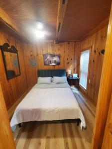a bedroom with a large bed in a wooden room at 109 Vinewood Cabin-1 Bedroom in Brewton
