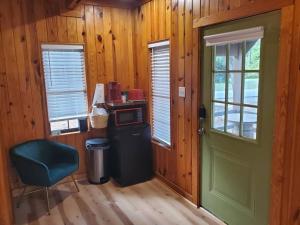 a room with a green door and a desk and a chair at 109 Vinewood Cabin-1 Bedroom in Brewton