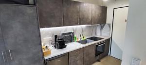 a kitchen with brown cabinets and a sink and a counter at Myrteni studio I in Nea Peramos