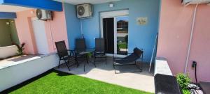 a patio with chairs and a table on a building at Myrteni studio I in Nea Peramos