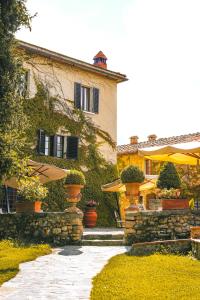 a building with plants and umbrellas in front of it at Borgo San Luigi in Monteriggioni