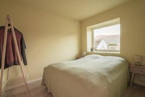 トロムソにあるLuxury top floor apartmentのベッドと窓のある寝室