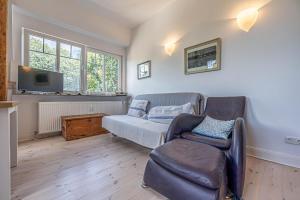 a living room with a couch and a chair at fewo1846 - Am Walfischstein - strandnahe 2-Zimmer-Wohnung im 1 OG in eleganter Jugendstilvilla in Westerholz