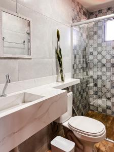 a white bathroom with a toilet and a sink at Kadosh Pipa Hospedagem in Pipa +74 photos