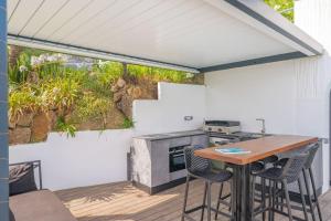 une cuisine extérieure avec une table et des chaises sur une terrasse dans l'établissement Villa Emilia, vue mer, Super-Cannes, à Vallauris