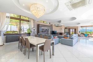 une salle à manger et un salon avec une table et des chaises dans l'établissement Villa Emilia, vue mer, Super-Cannes, à Vallauris