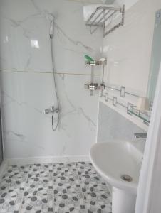 une salle de bain blanche avec un lavabo et des toilettes dans l'établissement Homestay Gia Đình, à Buôn Kao 22 autres photos