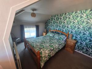 The Pebbles في ويتبي: غرفة نوم بسرير وورق جدران استوائي