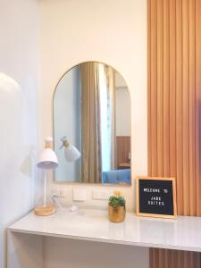 a bathroom with a mirror and a sign on a counter at Jabe Suites in Bacolod
