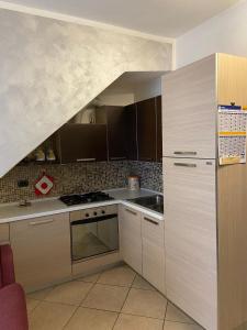 una cucina con lavello e fornello forno superiore di Bilocale L' Antica Corte ad Appiano Gentile