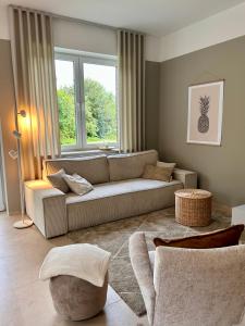 un soggiorno con un divano e una grande finestra di Ferienwohnung Clemens, neue Wohnung zentral und hochwertig ad Ahaus