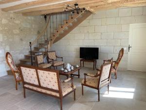 a living room with a table and chairs and a staircase at Fermette Tourangelle in Bréhémont