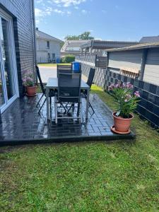 a patio with two chairs and a table and some plants at Pension Imhof in Oyten