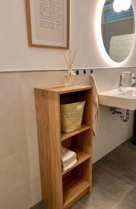 un bagno con mensola in legno accanto a un lavandino di Ferienwohnung Clemens, neue Wohnung zentral und hochwertig ad Ahaus