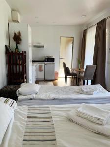 two beds in a room with a kitchen and a table at Cozy recreation area with a cabin in Šeduva