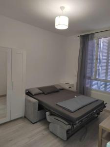 a bed sitting in a room next to a window at Studio à deux pas du métro in Gennevilliers