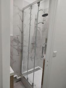 a shower with a glass door in a bathroom at Studio à deux pas du métro in Gennevilliers