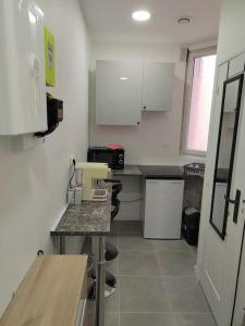 a kitchen with white cabinets and a counter top at Studio à deux pas du métro in Gennevilliers