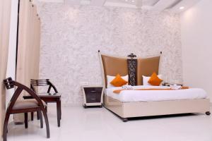 a bedroom with a bed and a desk and a chair at Nirmal Hotel And Resort in Bareilly