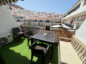 a balcony with a table and chairs on a roof at AirCon Los Cristianos, Quiet zone, Chipeque appartment in Arona