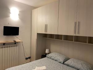 una camera con letto, TV e armadi di Bilocale L' Antica Corte ad Appiano Gentile
