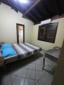 a bedroom with a bed and a table in it at Casa de maresias in São Sebastião +20 photos