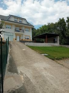 ein Haus mit einem Zaun neben einer unbefestigten Straße in der Unterkunft Casa turismo rural Becar in Corullón
