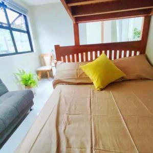 a bedroom with a large bed with a yellow pillow at Brent hill Condominium 1bedroom & studio units in Baguio